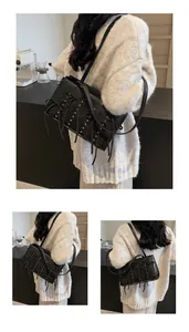 Detailed view of black suede shoulder bag with metallic studs and long fringe tassels