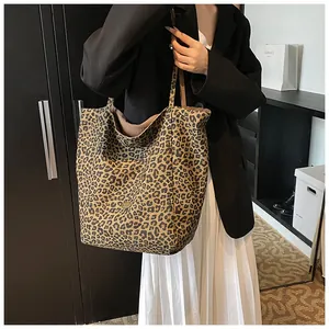 Fashionable leopard print shoulder bag worn with a black blazer and white pleated skirt