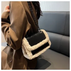Detail showing the contrast of black glossy leather and soft white shearling on the bag