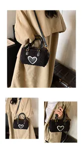 Detail van pluche cilindertas met hartpatch getoond op een model in trenchcoat