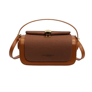 Vue détaillée du sac bicolore avec fermoir en métal coquille et texture tissée