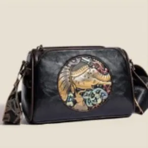 Vintage black embossed pillow bag with ethnic elephant inlay and wide patterned strap