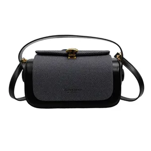 Détail du sac à main bicolore montrant le tissu sergé gris et le fermoir en métal doré