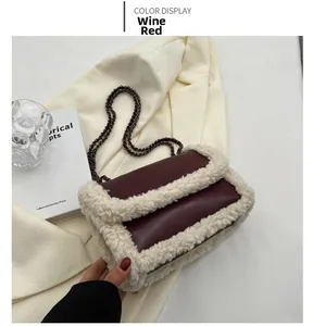 Detail of wine red leather shoulder bag with white faux fur trim and metal chain strap