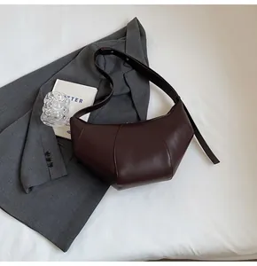Détail du sac à bandoulière en similicuir marron avec coutures verticales décoratives