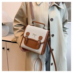 Detailed close-up of the vintage canvas and leather contrast handbag with a metal bow accent