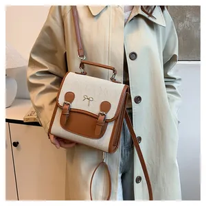 Detail of vintage canvas and brown leather contrast tote with gold bow and buckles