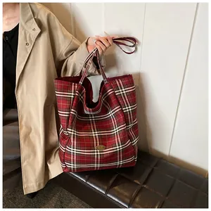Macro shot of red plaid fabric texture and handmade tag on the stylish tote bag