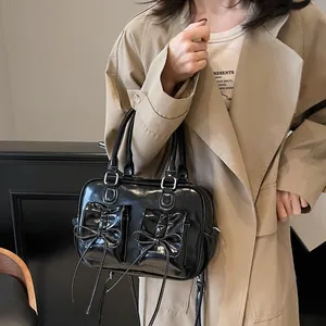 Chic black patent leather bow handbag with vintage pleated texture and white stitching