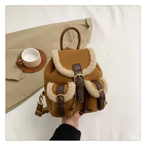 Close-up of brown suede mini backpack with white fleece trim and leather buckle details