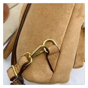 Detail of light brown suede fabric with premium gold hardware and smooth edge oiling