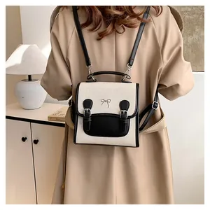 Detailed back view of woman wearing a mini canvas backpack with bow and contrast trim
