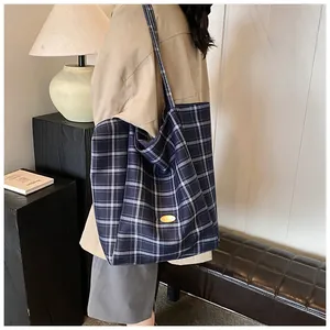 Deep blue and white checkered canvas tote bag with a golden metal logo plaque
