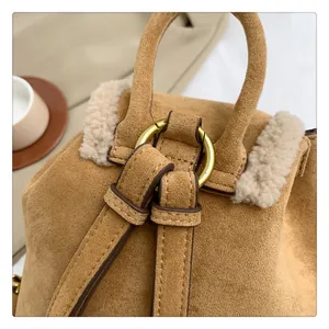 Detail of camel suede backpack with plush faux fur trim and gold metal ring hardware