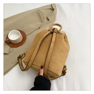 Detailed top view of a brown suede mini backpack with cozy beige plush fleece trim
