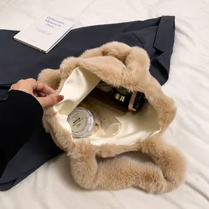 Vista interior del bolso tote grande de peluche beige que muestra su capacidad para cosméticos