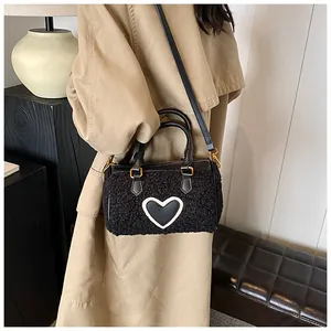 Pluche handtas met hart gedragen bij een kaki trenchcoat voor een winterse look