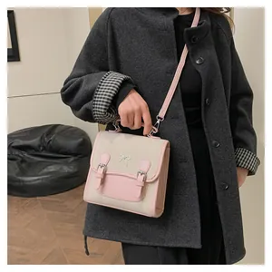 Detail of beige canvas and pink leather contrast small square backpack with bow accent