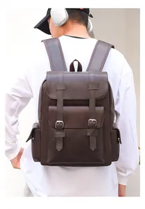 Detail of dark brown faux leather backpack with silver buckles and large front flap pockets