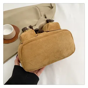 Detail of brown suede backpack with white faux fur handle and leather knot trim