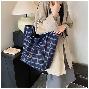 Close-up of classic blue and white plaid canvas tote bag with an oval brand logo plate