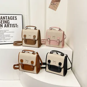 Preppy style canvas small backpack with metal bow and contrast faux leather detail