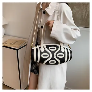 Close-up of a cylinder bucket bag with black and white geometric patterns and chain strap