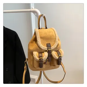 Detail of ginger suede backpack featuring white faux fur trim and gold metal buckles