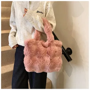 Detalle del bolso tote de piel sintética rosa con textura suave y asas gruesas