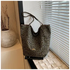 Detailed view of leopard print shoulder bag with canvas texture and metal logo