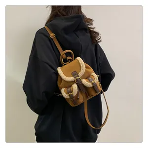 Detail of vintage brown suede and white sherpa patchwork backpack with brass buckles
