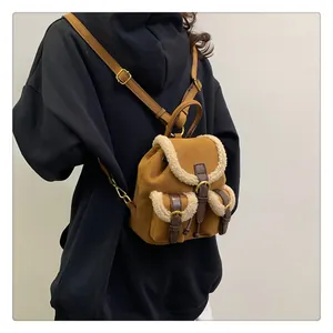 Detail of plush camel suede mini backpack with faux shearling trim and brown leather straps