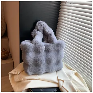 Vista detallada del bolso tote gris de felpa con asa anudada y textura acolchada