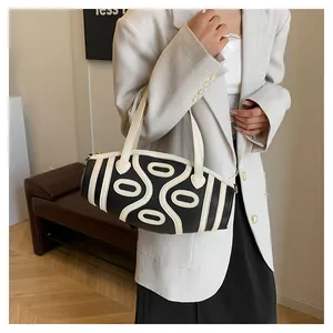 Detailed view of bucket bag with black and white geometric lines and golden zipper detail