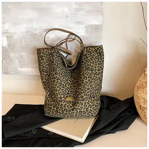 Detail of metal logo plaque on leopard print tote bag with stylish lifestyle props