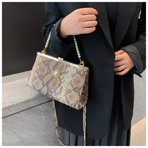 Détail du sac vintage à motif serpent avec poignée en perles et fermoir doré