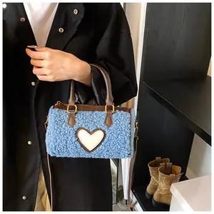 Detail van de blauwe pluche handtas met wit hartpatroon en bruine kunstlederen handgrepen