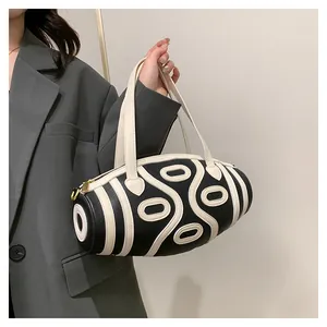 Detail of lychee pattern leather and cream-colored stitching on the bucket bag