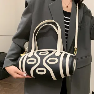 Minimalist black and white striped cylindrical bucket bag with leather handles and strap