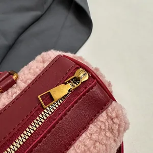 Macro-opname van gouden metalen rits op roze pluche handtas met leren details