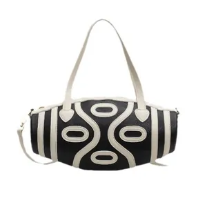 Minimalist black cylinder handbag with white contrast stripes and unique leather applique