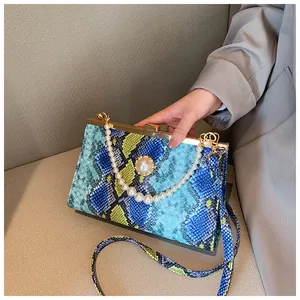 Détail du sac à main texturé serpent avec chaîne en perles et fermoir en métal chic