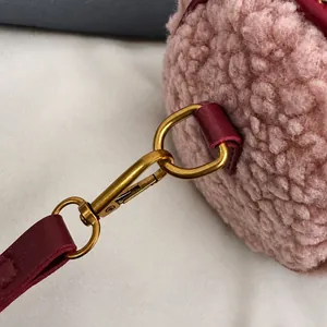 Detailopname van de premium metalen haak en lederen riem op de roze pluche tas