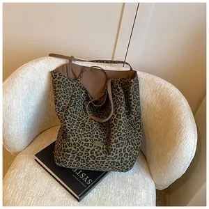 Detail of leopard print canvas tote bag with brown handle and gold metal plate