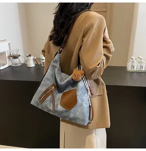 Blue washed leather hobo bag with brown pockets and decorative scarf on model