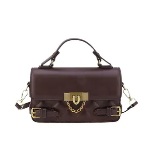 Sac bandoulière marron matelassé avec détails dorés et poignée dans un style épuré