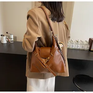 Detalle del bolso tote grande marrón vintage con solapa y hebilla metálica en el modelo