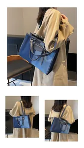 Detalle del bolso tote patchwork de denim azul con cremalleras doradas grandes