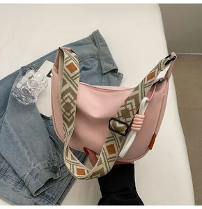 Detailaufnahme der pinkfarbenen Nylontasche mit buntem, ethnisch gewebtem Breitriemen