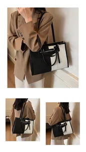 Detalle del bolso tote de lona bicolor con cremallera metálica y adorno de borla